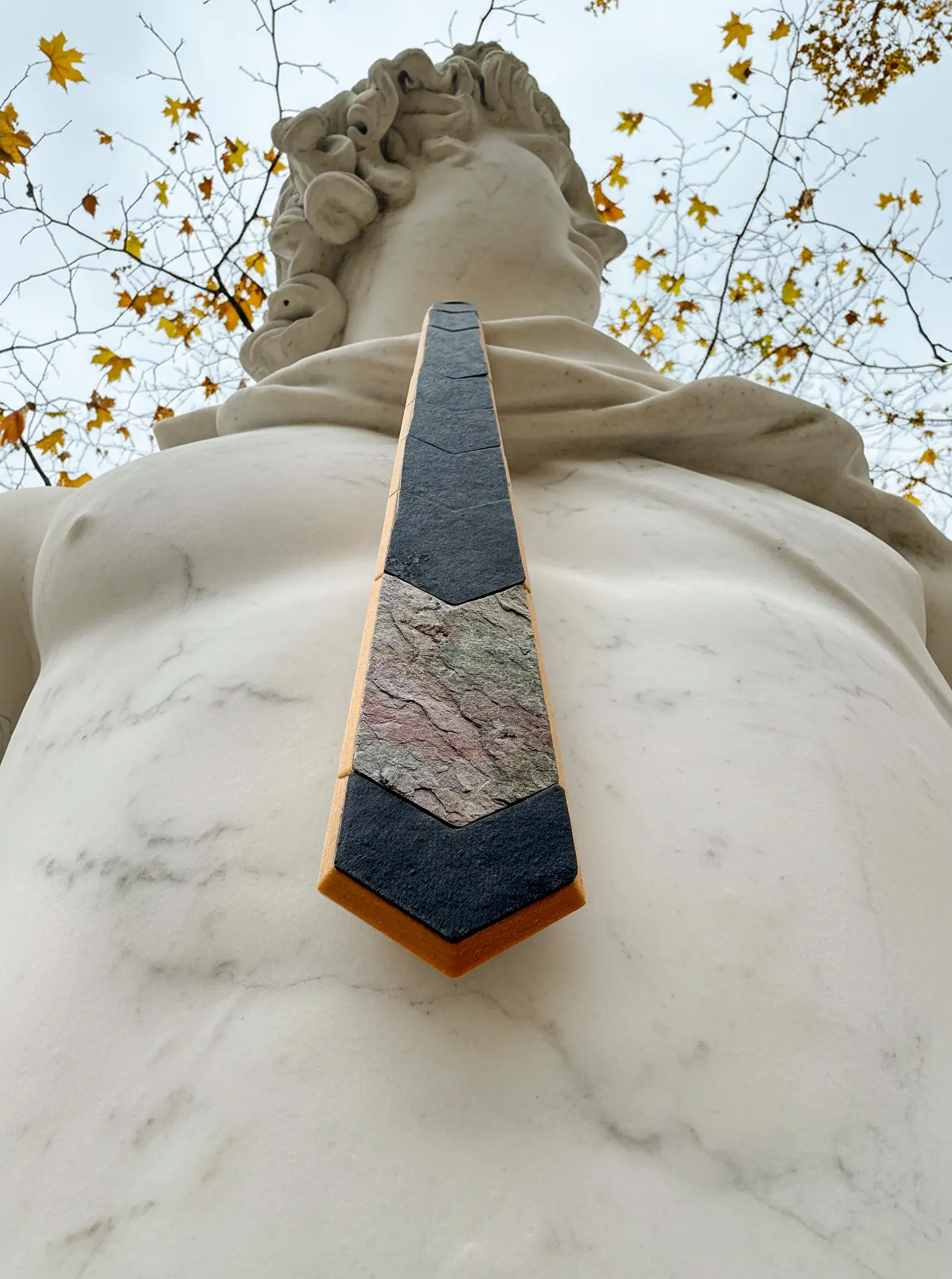 Pyroklast Krawatte mit Schiefersegmenten von einer Statue getragen