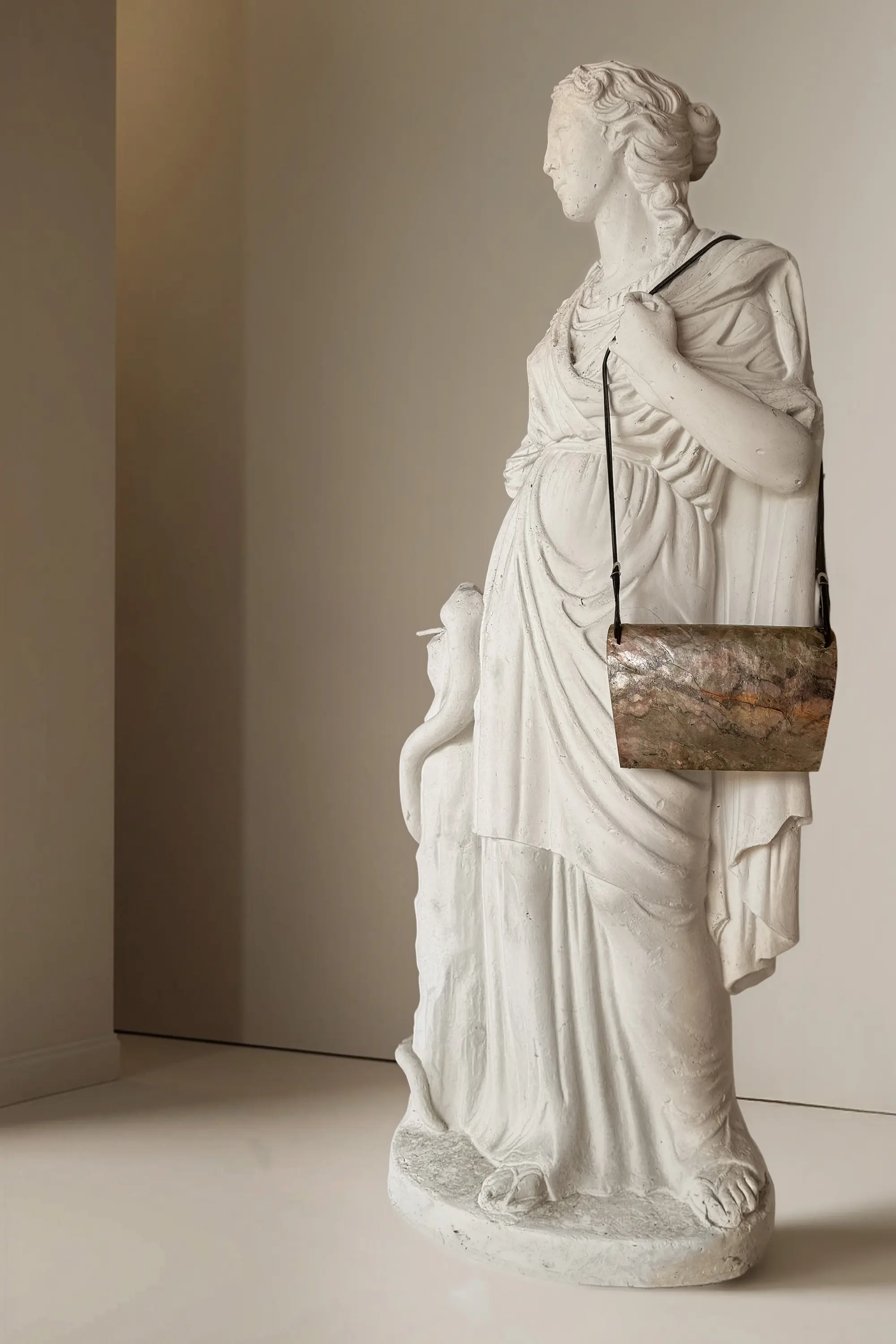 Pyroklast Abendtasche von einer weißen Statue getragen